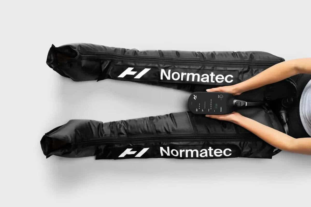 Botas de compresión de presoterapia con sus cámaras de aire junto al equipo Normatec