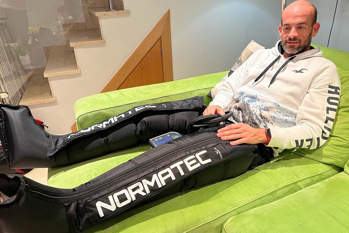 Paciente relajado y semirreclinado durante una sesión de presoterapia en consulta de fisioterapia